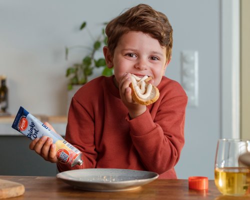 Søt gutt spiser skinkeost