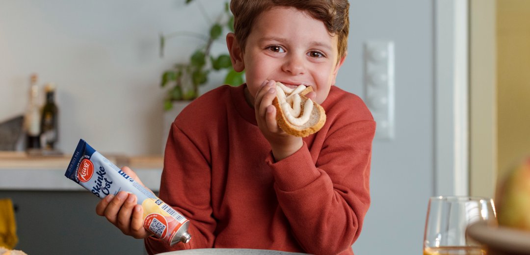 Søt gutt spiser skinkeost